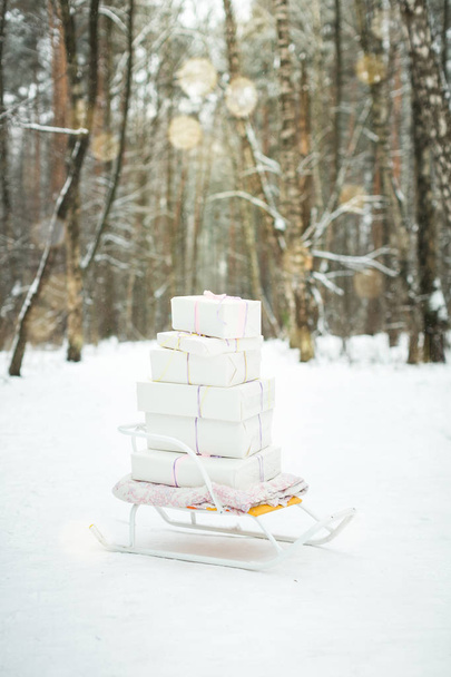 winter sledge with gift boxes in forest - Foto, imagen