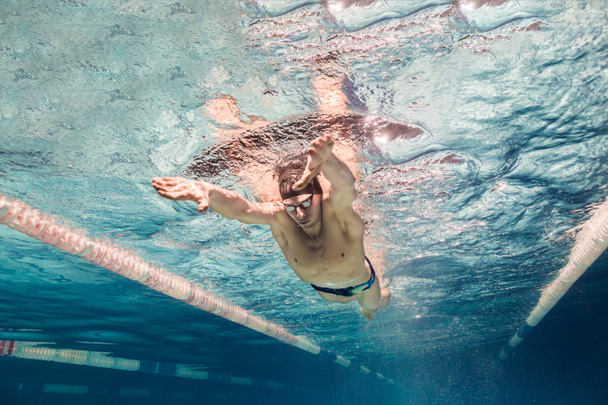 podwodne zdjęcia młodych pływak w czapkę i okulary szkolenie w basenie - Zdjęcie, obraz