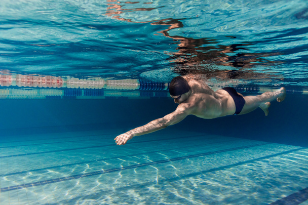 photo sous-marine de jeune nageur en casquette et lunettes de formation dans la piscine
 - Photo, image