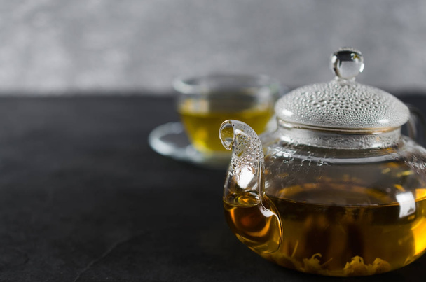 Чашка вкусного травяного чая и стеклянный чайник
. - Фото, изображение