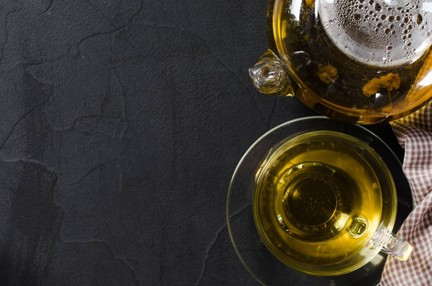 Φλιτζάνι νόστιμα βότανα τσάι και γυάλινη τσαγιέρα. - Φωτογραφία, εικόνα