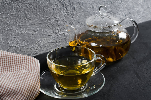 Cup of delicious herbal tea and glass teapot. - Foto, Bild