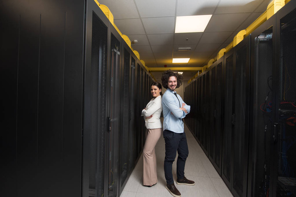 engineer showing working data center server room to female chief - Foto, Imagem
