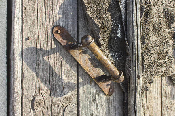 Antique door handle on a wooden door. Old Wood Texture  - Photo, image