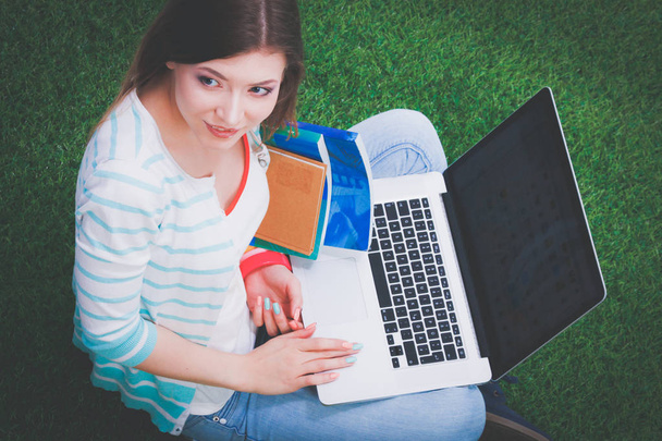 Young woman with laptop sitting on green grass . Portreit young woman - Фото, зображення