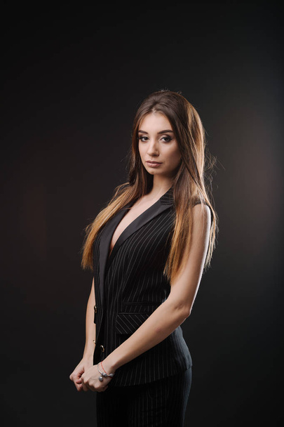 Beautiful young woman in  dress clothes posing in studio - Фото, зображення