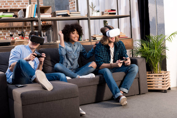 amis multiculturels jouer à un jeu vidéo avec des casques de réalité virtuelle
 - Photo, image