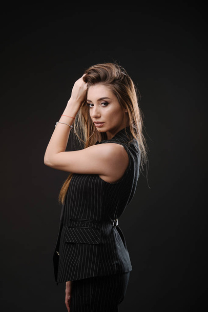 Beautiful young woman in  dress clothes posing in studio - Photo, image