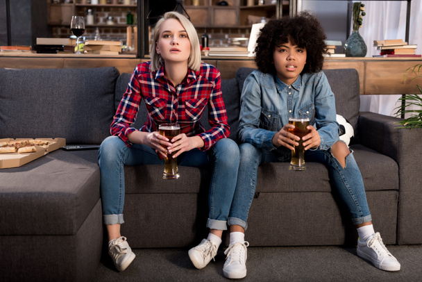 multicultural girls watching football on tv with beer - Фото, зображення