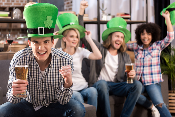 happy multicultural friends celebrating patricks day with beer at home - Foto, Imagen