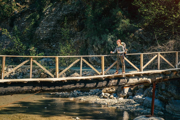 Hiker on the wooden bridge over mountain river in Turkey - Photo, Image