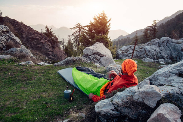 männliche Wanderer ruhen sich aus, trinken Kaffee und genießen neblige Landschaft - Foto, Bild