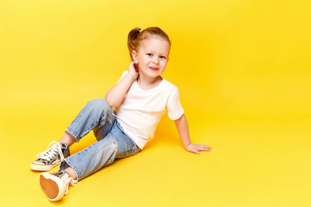 Adorable stylish girl posing on yellow background - Foto, Imagem
