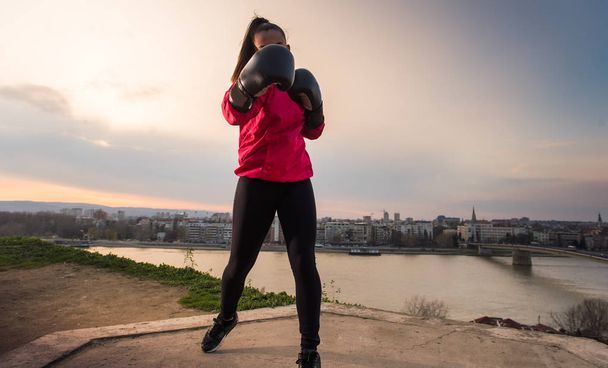 Młoda dziewczyna w rękawicach bokserskich rzucanie punch - sztuki walki - Zdjęcie, obraz