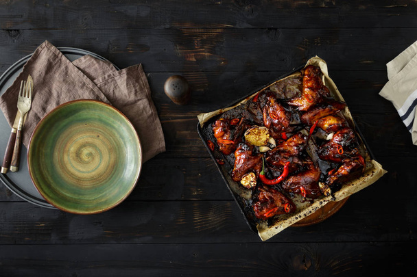 Top view baked chicken wings in soy sauce with honey on dark wooden table - 写真・画像
