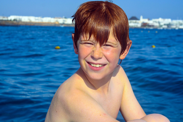 χαριτωμένο αγόρι σε μια βάρκα με υγρό δέρμα - Φωτογραφία, εικόνα