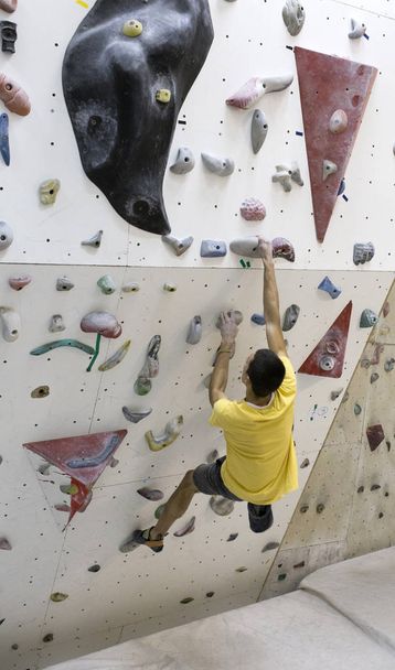 Indoor rock climbing man - Foto, afbeelding