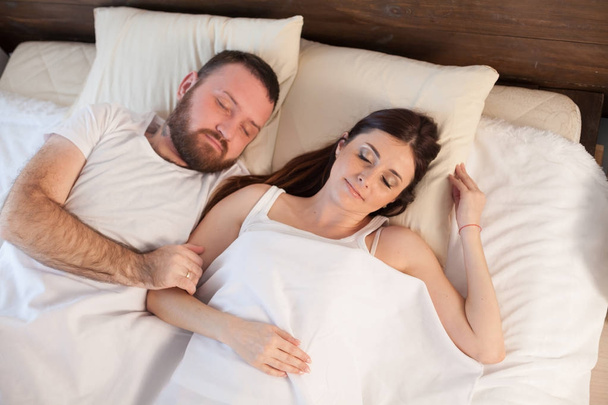 a man with a woman sleeping in beds bedroom - Фото, зображення