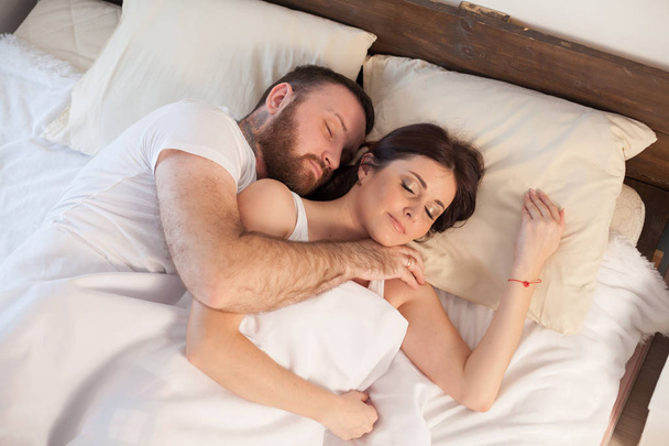 egy férfi, egy nő alvás ágy a hálószobában - Fotó, kép