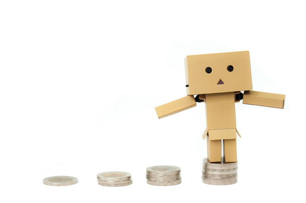  銀のスタックの一番上に立っている紙人形はコインに孤立した白い背景です。(選択と集中) - 写真・画像