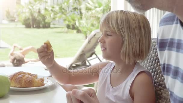 Gelukkige jonge familie ontbijten in de keuken op vakantie - Video