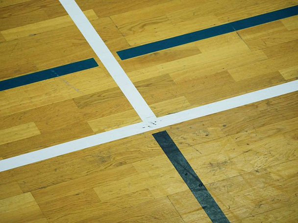 Ξύλινο πάτωμα γήπεδο μπάσκετ. Αθλητική αίθουσα με ισχυρή αστραπή, sratches - Φωτογραφία, εικόνα