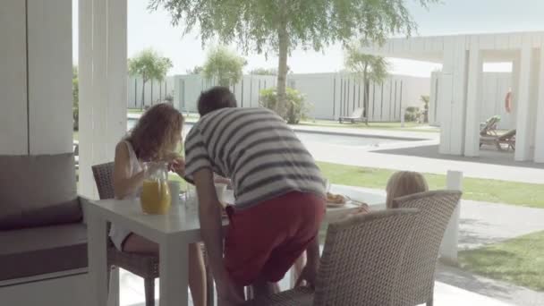 Szczęśliwa rodzina młodych o śniadanie w kuchni na wakacje - Materiał filmowy, wideo