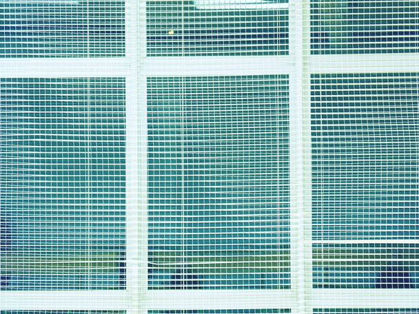 Protección de la seguridad de las ventanas en el pabellón deportivo. Ventana cubierta con red de seguridad tejida
. - Foto, imagen