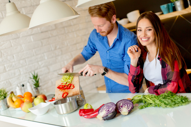 Szép fiatal házaspár készül a modern konyhában egészséges étkezés - Fotó, kép