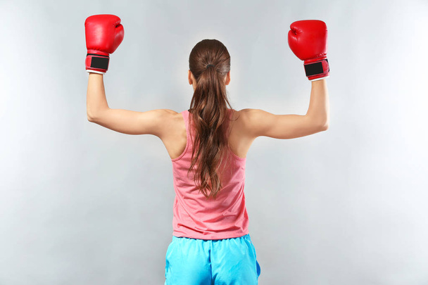 Strong woman in boxing gloves on grey background - Φωτογραφία, εικόνα