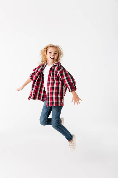 Full length portrait of an excited little girl jumping - Foto, Bild