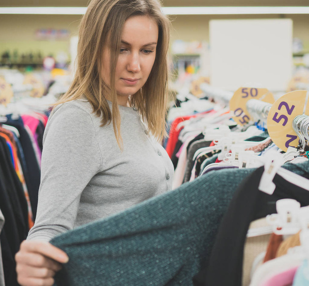 Mulher escolhendo suéter na loja de roupas
. - Foto, Imagem
