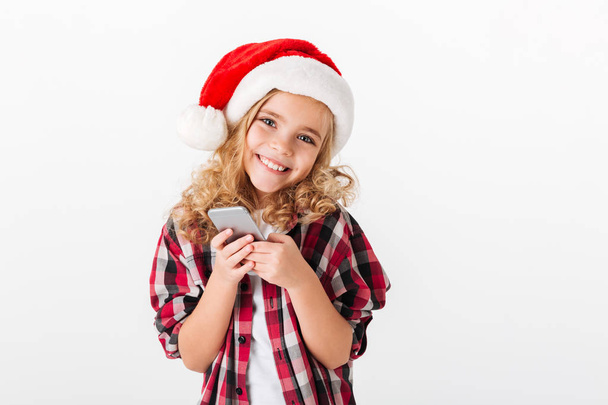 Portrait of a lovely little girl dressed in christmas hat - Foto, Imagen