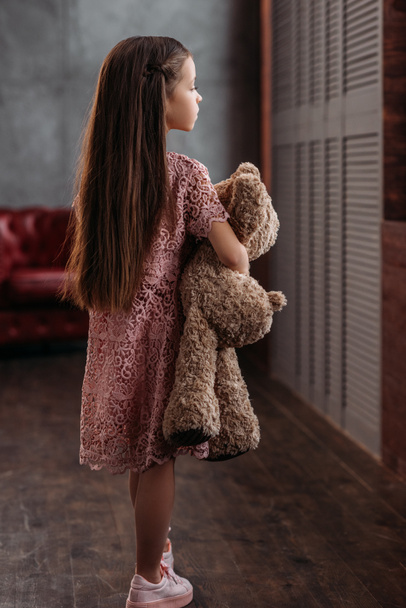 adorable little child holding teddy bear at loft apartments - Photo, image
