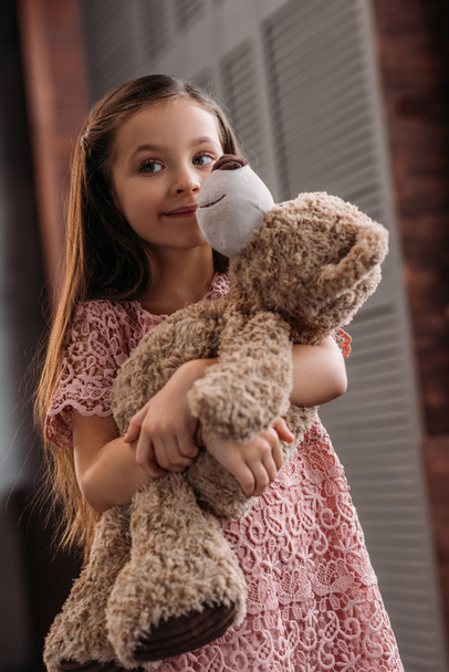 adorable little child embracing teddy bear at home - Photo, Image