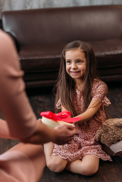 mother giving birthday gift to happy little daughter - Photo, Image