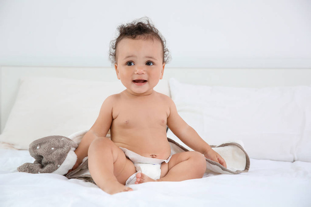 Cute little baby with towel after bathing on bed at home - Photo, image