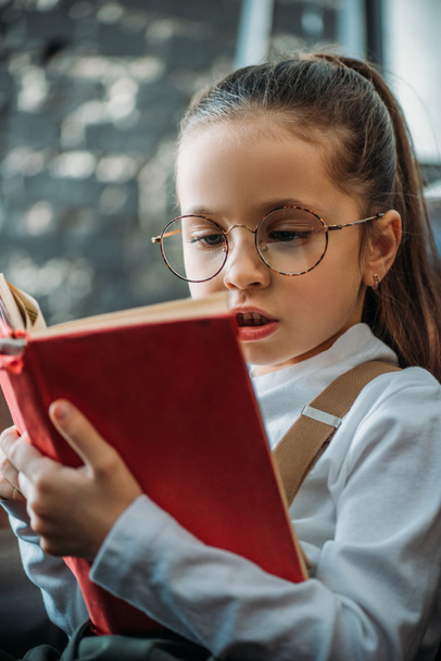 close-up portrait of concentrated little child reading book - Foto, Imagem