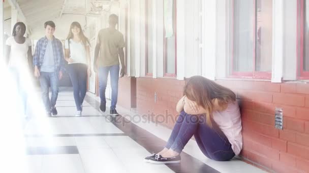 groep tieners wandelen in de hal van de school en het pesten een meisje zittend op de vloer en huilen - Video