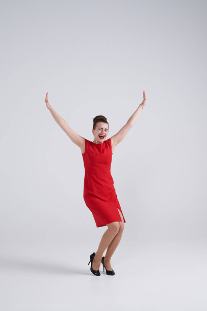 Opgewonden brunette in rode jurk uitdijende handen  - Foto, afbeelding