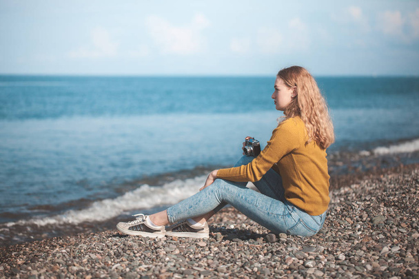 krásná blond dívka na pláži moře se starou kamerou v ruce - Fotografie, Obrázek