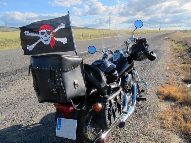 Moto preto com ossos cruzados em uma parada de rodovia
 - Foto, Imagem