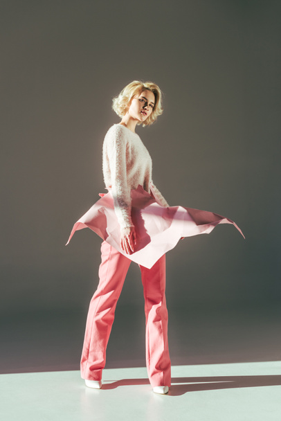 beautiful young woman posing with pink crumpled paper on waist in studio - Φωτογραφία, εικόνα