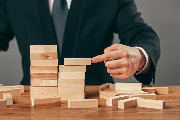 Man and wooden cubes on table. Management concept - Photo, image