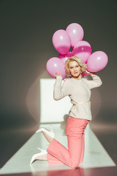 stylish young woman posing with pink balloons - Foto, afbeelding