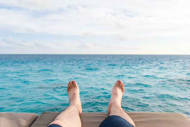 Man leg with sea in background. - 写真・画像