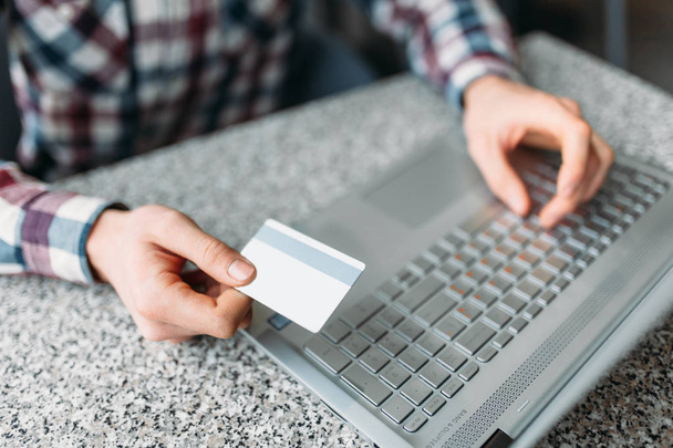 Mãos de perto, homem fazer compras através da Internet em um laptop, cartão de crédito
 - Foto, Imagem