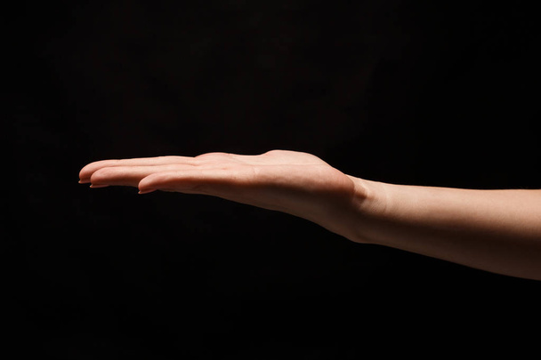 Žena držící dlaně otevřené izolované na černém pozadí - Fotografie, Obrázek