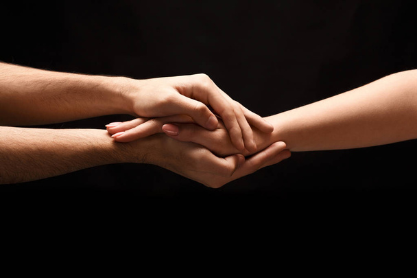 Руки чоловіка і жінки в любові, ізольовані на чорному
 - Фото, зображення