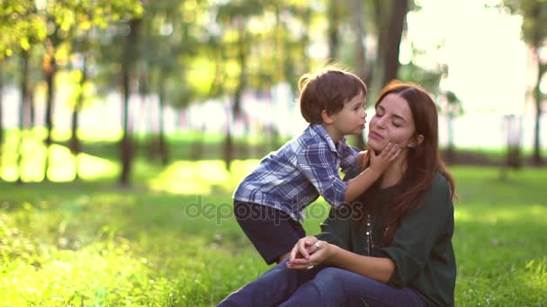 niño dando beso a la madre en el parque al atardecer. Movimiento lento
 - Imágenes, Vídeo